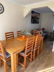 a wooden dining room table with chairs and a couch at Stunning cozy three bedroom house near ARI in Aberdeen