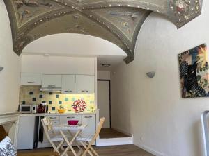 a kitchen with a table and chairs in a room at Studios - Menton Old Town - near the beach and shops in Menton +8 photos