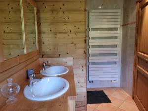 2 lavandini in un bagno con pareti in legno di La petite Anfiane a Le Grand-Bornand