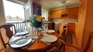 a kitchen with a wooden table with a vase of flowers at Sail Away in Eastbourne