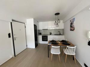 a kitchen with a table and two white chairs at WSD New! Amazing Lux 2BD Apt Glyfada Near Sea in Athens