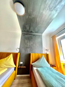 Duas camas num quarto com tecto em Sofia Apartment & Zimmer Knittelfeld em Knittelfeld