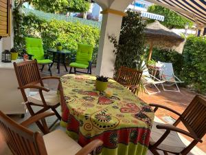 stół i krzesła na patio z zielonymi krzesłami w obiekcie Duplex Vera - Playa w mieście Vera