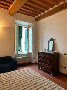 1 dormitorio con cama, tocador y espejo en Cav san Jacopo lungomare Livorno, en Livorno
