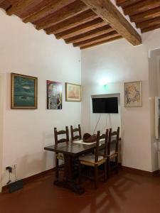 comedor con mesa, sillas y TV en Cav san Jacopo lungomare Livorno, en Livorno