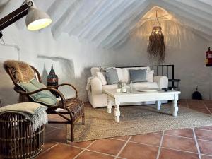 sala de estar con sofá, mesa y sillas en Finca Tranquilidad, en Iznájar