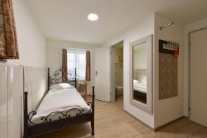 a small bedroom with a bed and a mirror at Hotel Hirschen in Zürich