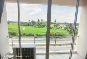 a room with a large window with a view of a golf course at 115 Townhouse in Ban Khlong Krang