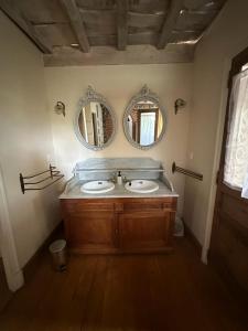 a bathroom with two sinks and two mirrors on the wall at Relais DAIA 