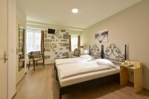 a bedroom with two beds and a desk and a chair at Hotel Hirschen in Zürich