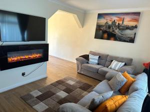 a living room with a couch and a fireplace at Stunning cozy three bedroom house near ARI in Aberdeen