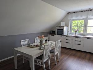 a kitchen with a white table and chairs in a room at Ferienwohnung Fischerteich in Detmold in Detmold