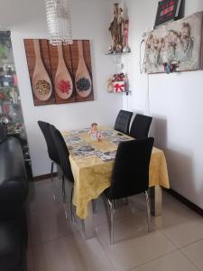 mesa de comedor con sillas negras y jarrones en la pared en Residencial Las Torres de Salaverry, en Chiclayo