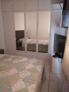 een slaapkamer met een bed en een flatscreen-tv bij Residencial Las Torres de Salaverry in Chiclayo