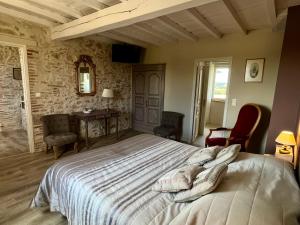 a bedroom with a large bed and a table and chairs at Le Mas De Marie in Lavaur