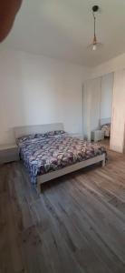 1 cama en un dormitorio con suelo de madera en IN PANDORA'S BOX 5 LANDS, en Vezzano Ligure