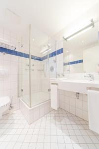 ein Bad mit einer Badewanne, einer Dusche und einem Waschbecken in der Unterkunft Hotel Kontorhaus Stralsund in Stralsund