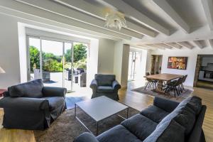 a living room with a couch and chairs and a table at La Villa Bel Air in Flamanville