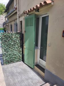 uma porta verde do lado de um edifício em Grand Studio, Parking privé, Cuisine séparée em Cannes