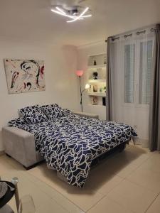 um quarto com uma cama com um edredão azul e branco em Grand Studio, Parking privé, Cuisine séparée em Cannes