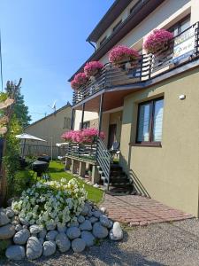 ein Haus mit Blumen auf den Balkonen und einem Haufen Steine in der Unterkunft Tu się śpi in Bodzentyn