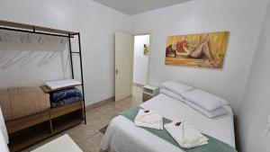 a bedroom with two beds and a painting on the wall at Residência bem localizada em Bento Gonçalves in Bento Gonçalves