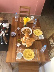 uma mesa de madeira com pratos de comida em Taza Organic Garden with view park and restaurant em Taza