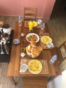 a wooden table with plates of food on it at Taza Organic Garden with view park and restaurant in Taza