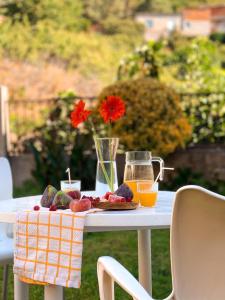 a table with a plate of fruit and orange juice at Villa del Jerte in El Torno