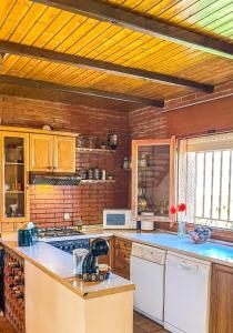 a large kitchen with wooden walls and wooden ceilings at Villa del Jerte in El Torno +37 photos