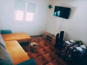 a living room with a couch and a table and a television at Apartman MR in Potpićan