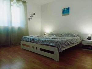 a bedroom with a bed with two lamps on it at Apartman MR in Potpićan