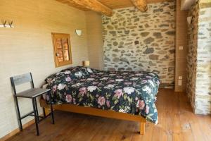 Un dormitorio con una cama en una pared de piedra. en L'Ange : Entre monts et vallées, en Retournac