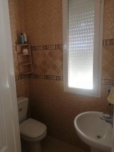 baño con aseo y lavabo y ventana en Bensassi Urban Escape, en La Marsa