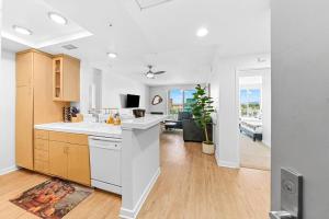 a kitchen with white counter tops and a living room at Emerald Gem 2bedroom 2bath With Full Marina View in Los Angeles