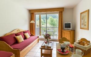 a living room with a couch and a table at Lagrange Vacances L'Ardoisière in Saint-Lary-Soulan