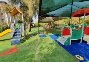 a park with a playground with a slide and swings at Spacious 3BD Penthouse with Rooftop & Parking in Ra‘ananna