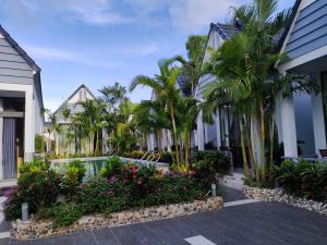 um pátio de uma casa com palmeiras e flores em Ngoc Trai Xanh Bungalow em Phu Quoc