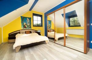 1 dormitorio con 2 camas y paredes amarillas en Szczęśliwe Ranczo nad Doliną 539-279-448, en Bereżnica Wyżna