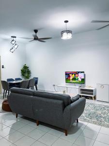 a living room with a couch and a tv at Homestay Ar-Rayyan 3 Ketereh in Ketereh