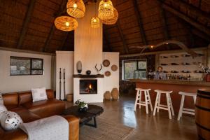 a living room with a couch and a fireplace at Elephants Crossing in Welgevonden Game Reserve +40 photos