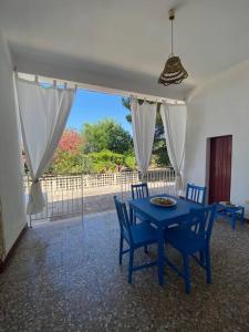 einen blauen Tisch und Stühle im Wohnzimmer in der Unterkunft Casa La Fineta in Maruggio