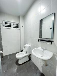 a white bathroom with a toilet and a sink at Homestay Ar-Rayyan 3 Ketereh in Ketereh