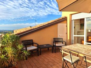 Un patio con sillas y una mesa en el balcón. en Hotel Lauri, en Macerata