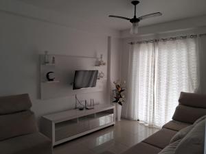 阿拉亞爾多卡博的住宿－APTO LINDO FRENTE PRAIA GRANDE，带沙发和电视的白色客厅