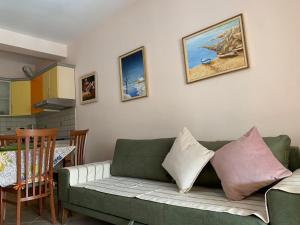 una sala de estar con un sofá verde con almohadas en Arbi's Pool View Apartment, en Golem