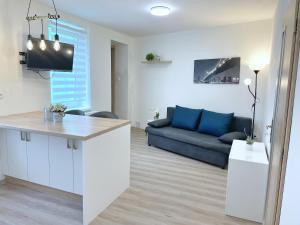 a kitchen and a living room with a blue couch at Apartmán U Náměstí in Telč