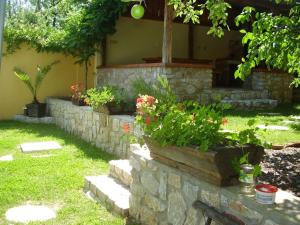 a stone retaining wall with flowers in a yard at Apartment Gemer & Volovec in Rožňava