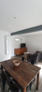 a living room with a wooden table and a couch at Le Refuge du Musée in Sacy-le-Grand
