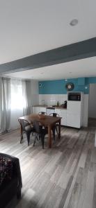 a living room with a wooden table and a kitchen at Le Refuge du Musée 